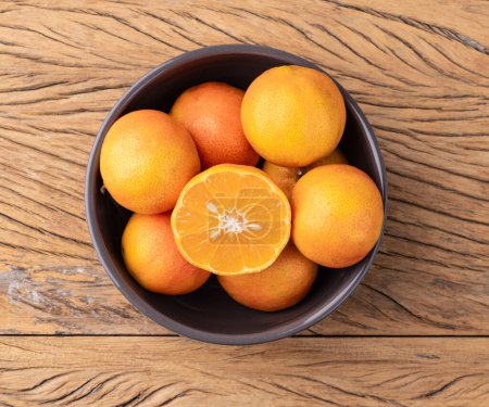 Téléchargez les photos : Cravo ou citrons roses dans un bol sur une table en bois. - en image libre de droit