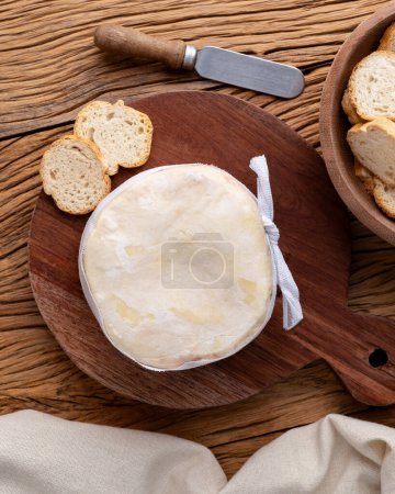 Queso Jordao, queso crema brasileño con tostadas sobre mesa de madera.