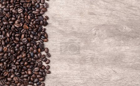 Photo for Closeup of coffee beans over rustic wooden table with copy space. - Royalty Free Image