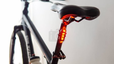 Photo for Close view of a red safety light attached to a black bicycle - Royalty Free Image