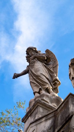 Photo for Recoleta, Buenos Aires, Argentina. 05-20-23: Close view of an angel stone sculpture, placed on top of an old mausoleum in Recoleta cemetery - Royalty Free Image