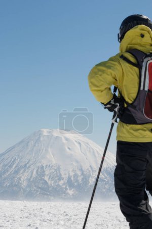 Photo for Man in skiwear standing looking at snow-capped mountain - Royalty Free Image