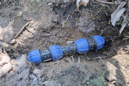 Photo for HDPE pipe joint. Union and HDPE pipe of plastic water pipe joint on the ground. Water well system for organic garden use with selective focus - Royalty Free Image