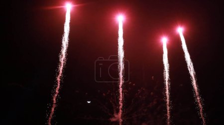 Feuerwerk am Himmel. Schöne Reihe von roten Feuerwerk vor einem Halbmond Nachthimmel mit Kopierraum mit selektiver Fokussierung.