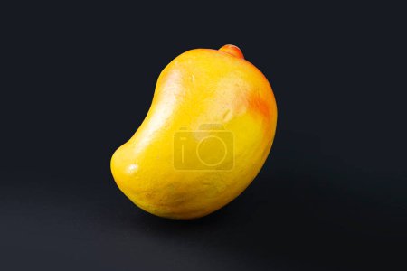 Photo for A clay made mango toy from Boishakhi mela. nicely yellow and red colored mango shaped mud toy on black background. - Royalty Free Image