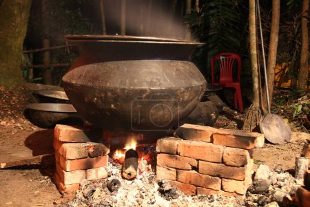 overnight cooking in a village party on a temporary brick made oven. Outdoor cooking for lots of people in large aluminum pan in wood fire. huge cooking at village in Bangladesh.