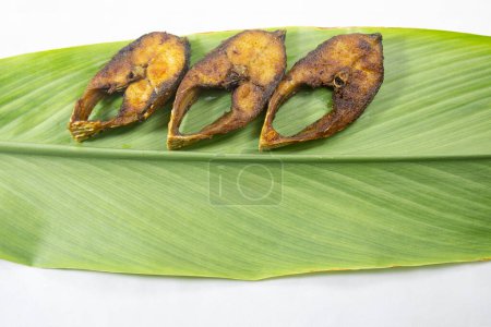 Photo for Fried Ilsha on Turmeric leaf. Hilsa fry is popular in pohela boishakh festival among Bengali's in India and Bangladesh. - Royalty Free Image