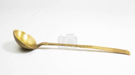 Empty golden brass spoon. traditional utensil for cooking and rituals during religious festivals. isolated in a white background. a brass ghee or curry serve spoon.