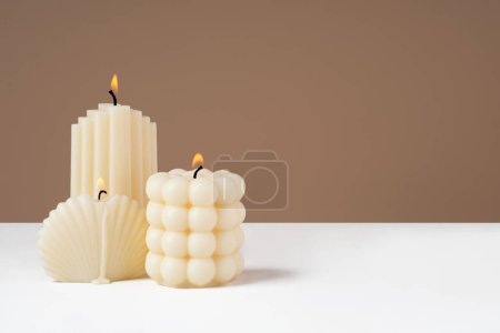 Photo for Handmade olive wax different forms burning candle on a duotone brown and white background. Sustainability vegan candle, natural materials. Minimalistic, cozy atmosphere modern photo.Copy space.Banner - Royalty Free Image