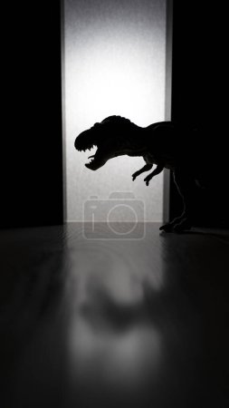 Téléchargez les photos : T Rex Dinosaure avec des dents acérées debout dans la pièce sombre - en image libre de droit