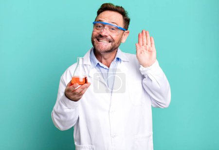 Photo for Middle age man smiling happily, waving hand, welcoming and greeting you. scientist concept - Royalty Free Image