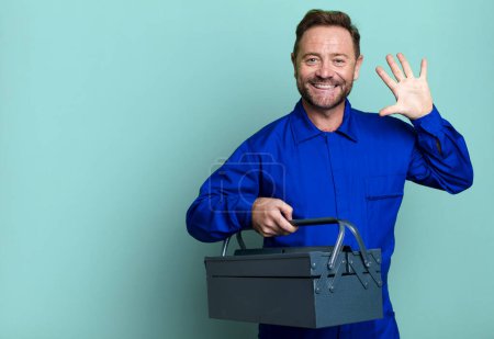 Photo for Middle age man smiling and looking friendly, showing number five. plumber with a toolbox concept - Royalty Free Image