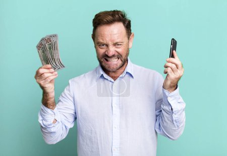 Foto de Hombre de mediana edad con billetes de dólar. concepto de compras en línea concepto de entrenador deportivo con una pelota de fútbol - Imagen libre de derechos