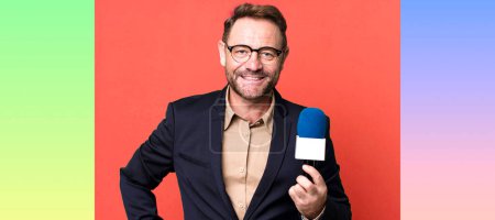 Photo for Middle age man smiling happily with a hand on hip and confident. journalist and a microphone concept - Royalty Free Image