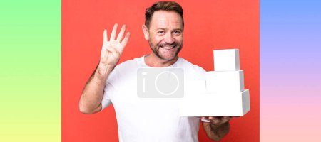 Foto de Hombre de mediana edad sonriendo y buscando amigable, mostrando el número cuatro. concepto de paquetes en blanco - Imagen libre de derechos