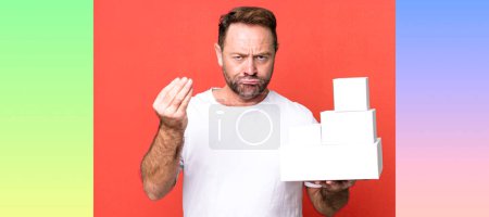Téléchargez les photos : Homme d'âge moyen faisant capice ou geste d'argent, vous disant de payer. concept de paquets vides - en image libre de droit