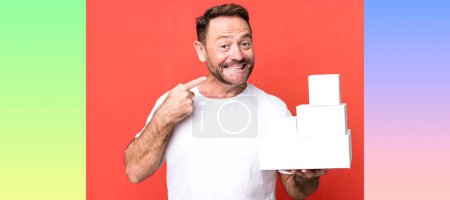 Foto de Hombre de mediana edad sonriendo con confianza apuntando a su propia sonrisa amplia. concepto de paquetes en blanco - Imagen libre de derechos