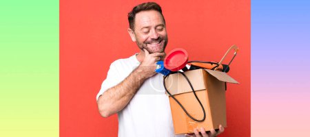 Photo for Middle age man smiling with a happy, confident expression with hand on chin. handyman with a toolbox - Royalty Free Image