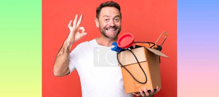 Foto de Hombre de mediana edad sintiéndose feliz, mostrando aprobación con gesto bien. manitas con caja de herramientas - Imagen libre de derechos