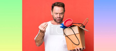 Photo for Middle age man making capice or money gesture, telling you to pay. handyman with a toolbox - Royalty Free Image