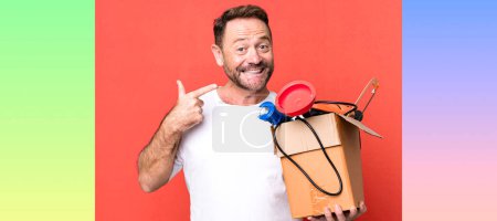 Foto de Hombre de mediana edad sonriendo con confianza apuntando a su propia sonrisa amplia. manitas con caja de herramientas - Imagen libre de derechos
