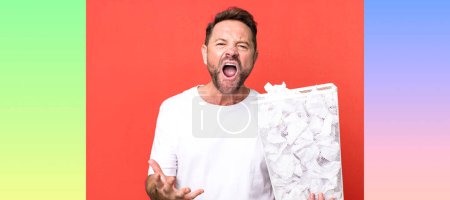 Photo for Middle age man looking angry, annoyed and frustrated. paper balls trash basket - Royalty Free Image