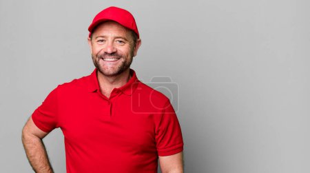 Téléchargez les photos : Homme d'âge moyen sourire heureux avec une main sur la hanche et confiant. employé de l'entreprise - en image libre de droit
