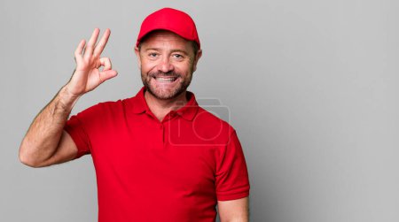 Téléchargez les photos : Homme d'âge moyen se sentant heureux, montrant l'approbation avec le geste correct. employé de l'entreprise - en image libre de droit