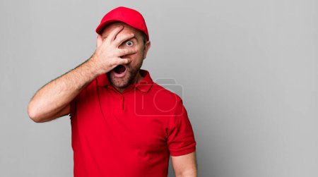 Photo for Middle age man looking shocked, scared or terrified, covering face with hand. company employee - Royalty Free Image