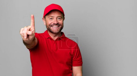 Photo for Middle age man smiling proudly and confidently making number one. company employee - Royalty Free Image