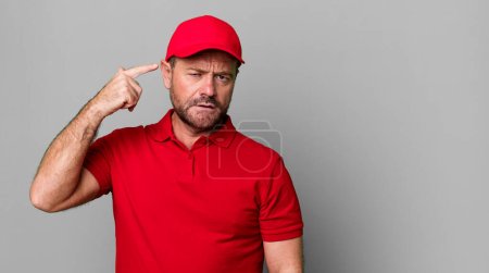 Photo for Middle age man feeling confused and puzzled, showing you are insane. company employee - Royalty Free Image