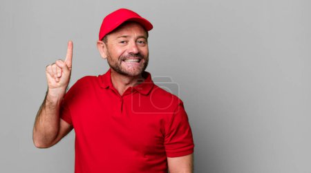 Photo for Middle age man smiling and looking friendly, showing number one. company employee - Royalty Free Image