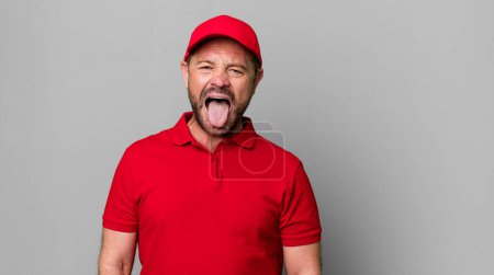 Téléchargez les photos : Homme d'âge moyen se sentant dégoûté et irrité et la langue. employé de l'entreprise - en image libre de droit