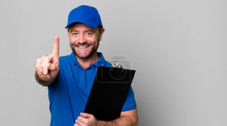 Photo for Middle age man smiling proudly and confidently making number one. company employee with an inventory - Royalty Free Image