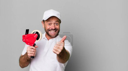 Téléchargez les photos : Homme d'âge moyen se sentant fier, souriant positivement avec les pouces levés. employé de l'entreprise - en image libre de droit