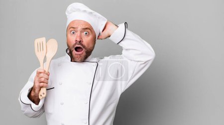 Photo for Middle age man feeling stressed, anxious or scared, with hands on head. chef and tools concept - Royalty Free Image