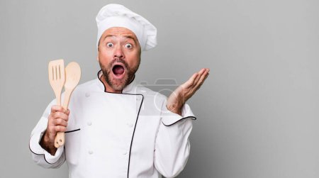 Foto de Hombre de mediana edad sintiéndose feliz y asombrado por algo increíble. concepto de chef y herramientas - Imagen libre de derechos