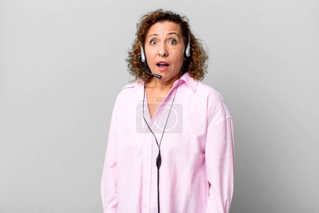 Photo for Pretty middle age woman looking very shocked or surprised with a headset. telemarketing concept - Royalty Free Image