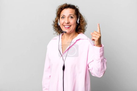 Foto de Mujer de mediana edad se siente como un genio feliz y emocionado después de darse cuenta de una idea con un auricular. concepto de telemarketing - Imagen libre de derechos