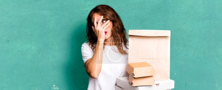 hispanic pretty woman feeling bored, frustrated and sleepy after a tiresome. take away fast food packages concept