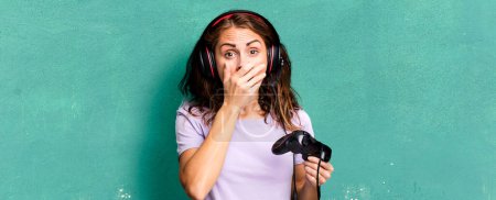 Photo for Hispanic pretty woman covering mouth with hands with a shocked. gamer concept - Royalty Free Image