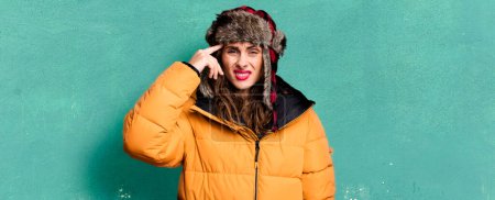 Photo for Hispanic pretty woman feeling confused and puzzled, showing you are insane. wearing an anorak. cold and winter concept - Royalty Free Image