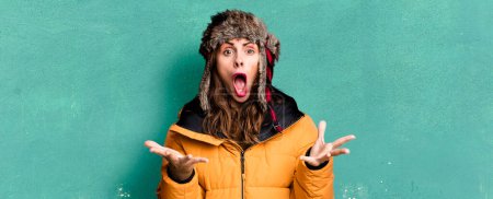 Photo for Hispanic pretty woman feeling extremely shocked and surprised. wearing an anorak. cold and winter concept - Royalty Free Image