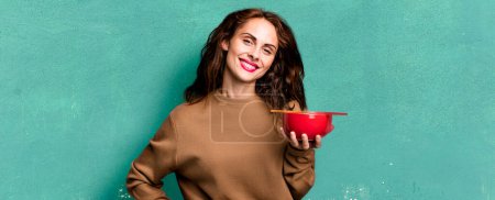 Photo for Hispanic pretty woman smiling happily with a hand on hip and confident - Royalty Free Image