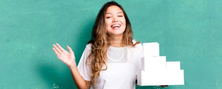 Téléchargez les photos : Hispanic pretty woman feeling happy, surprised realizing a solution or idea with white boxes packages - en image libre de droit