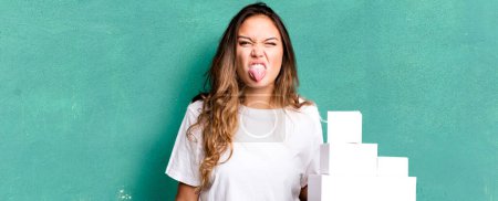 Photo for Hispanic pretty woman feeling disgusted and irritated and tongue out with white boxes packages - Royalty Free Image