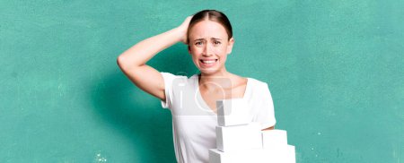 Téléchargez les photos : Caucasian pretty woman feeling stressed, anxious or scared, with hands on head with white boxes packages - en image libre de droit
