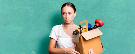 Photo for Caucasian pretty woman feeling sad, upset or angry and looking to the side with a tool box. repair home concept - Royalty Free Image