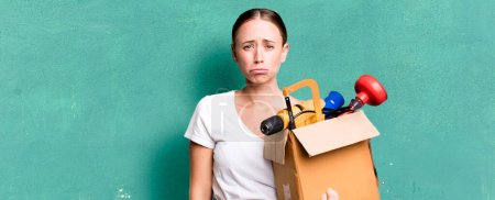 Photo for Caucasian pretty woman feeling sad and whiney with an unhappy look and crying with a tool box. repair home concept - Royalty Free Image