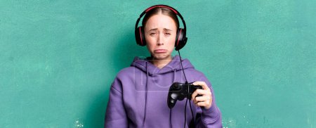 Foto de Caucasian pretty woman feeling sad and whiney with an unhappy look and crying. gamer concept - Imagen libre de derechos